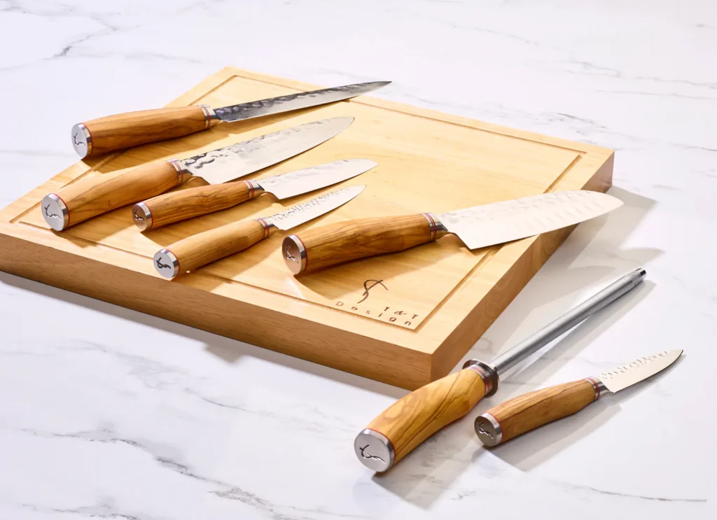 Set Japanse messen met olijfhouten heft op een lichte houten snijplank op wit marmer