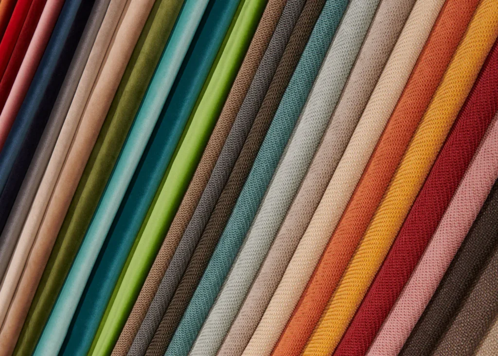 Waaier van stofstalen in veel kleuren, van zacht beige tot oranje, blauw en groen, om een zetel op maat te kiezen